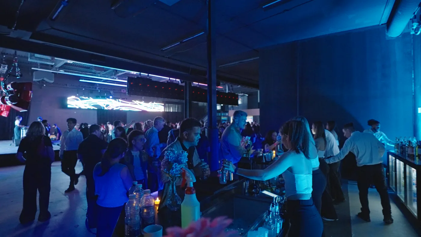 The same room reset into an evening mixer with a full crowd