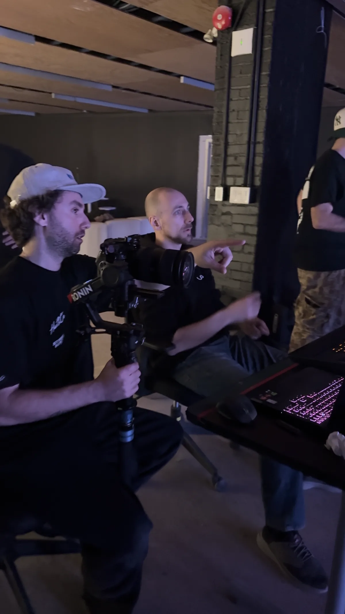 Camera crew operating a gimbal rig and reviewing a monitor on set